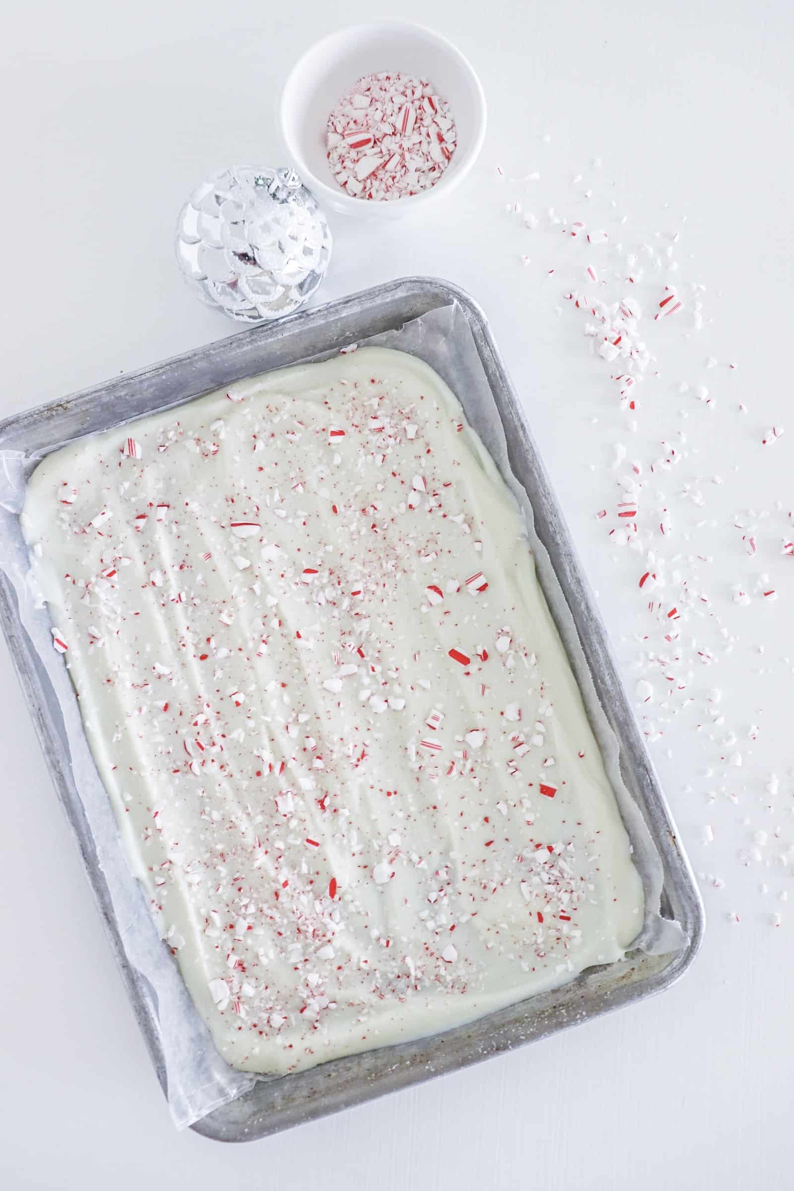 A baking tray topped with chilled white chocolate peppermint bark.