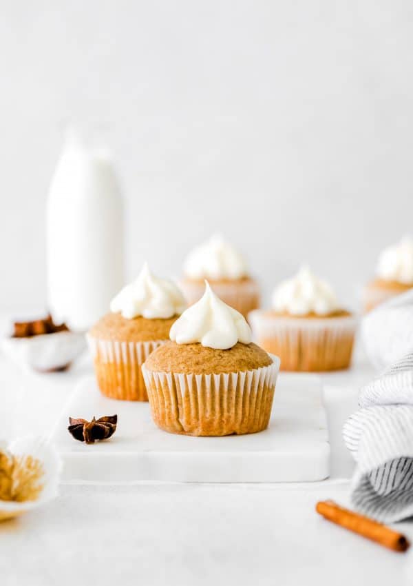 A prepared spice cupcakes with a squirt of cream cheese frosting on top of it.