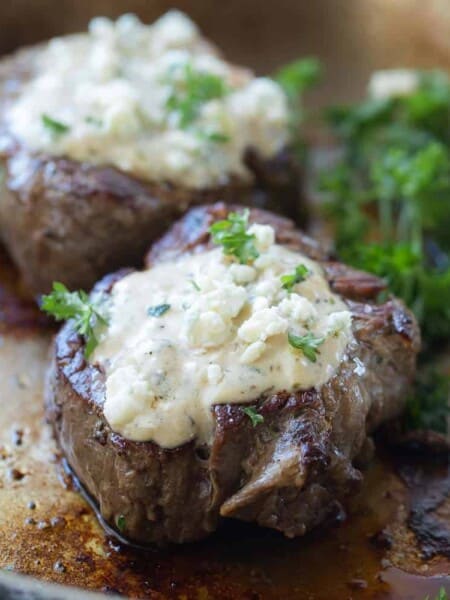 fillet mignon with a creamy blue cheese sauce in a skillet