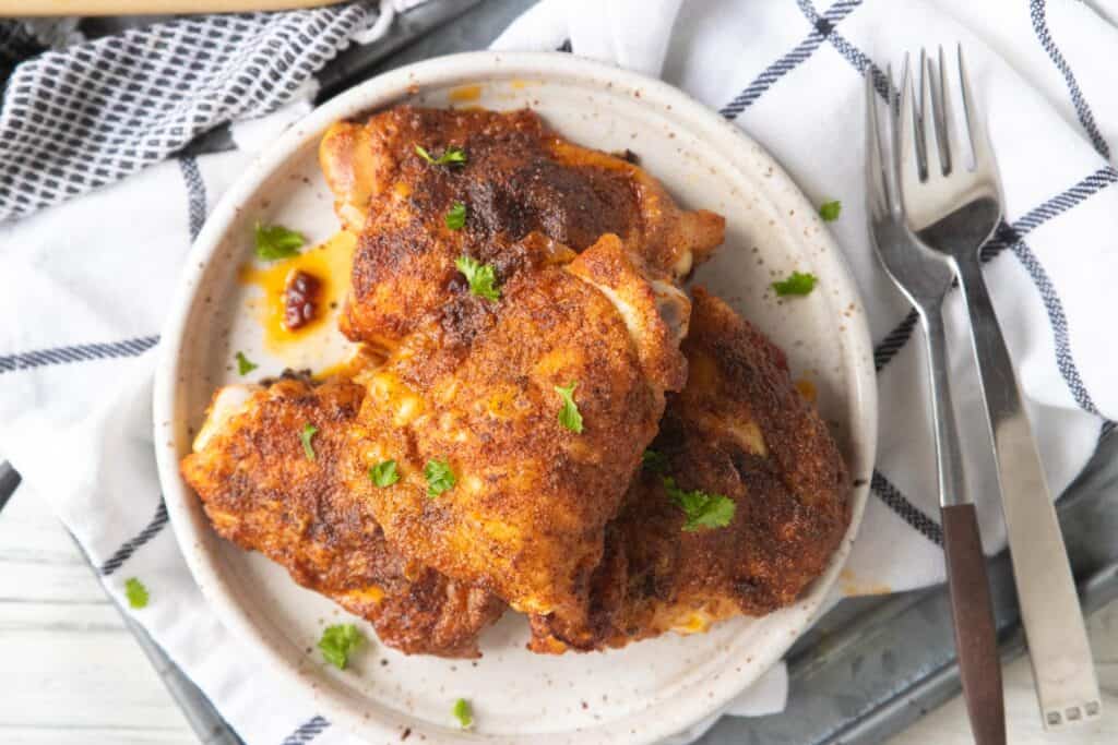 crispy chicken thighs shown top down on a plate