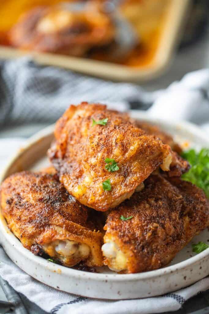 crispy chicken thighs shown on a plate with parsley