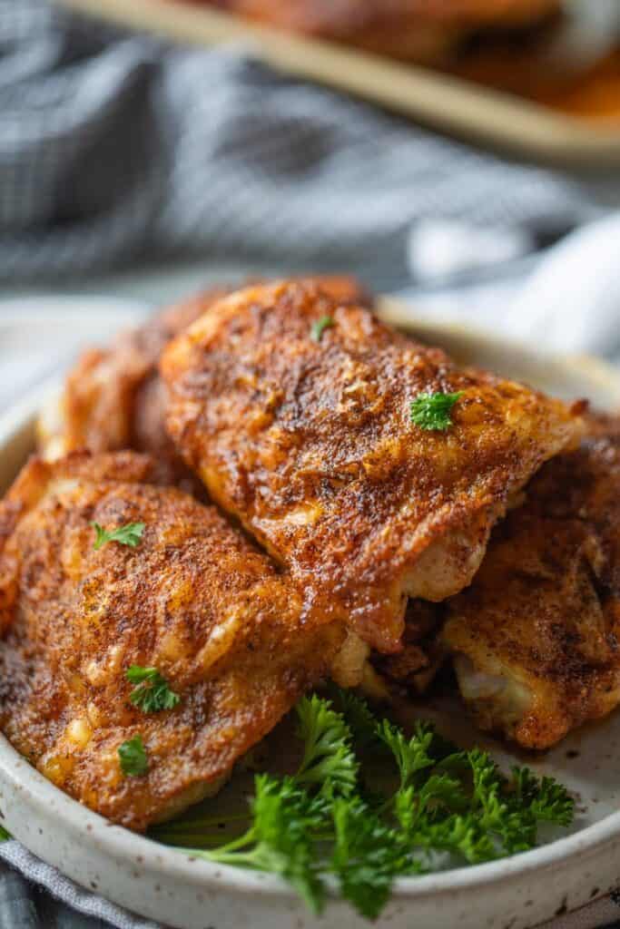 seasoned crispy chicken thighs shown on a plate