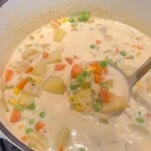 a ladle scooping dairy free potato soup in a stockpot