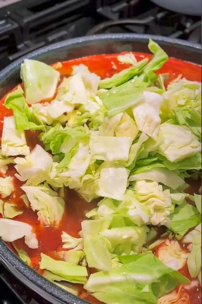 cabbage added to a soup in a pot